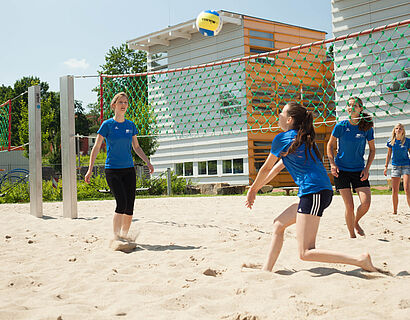 Studierende spielen Beachvolleyball