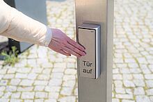 Barrierencheck Barrierencheck, Hand drückt Türöffner für Automatiktür