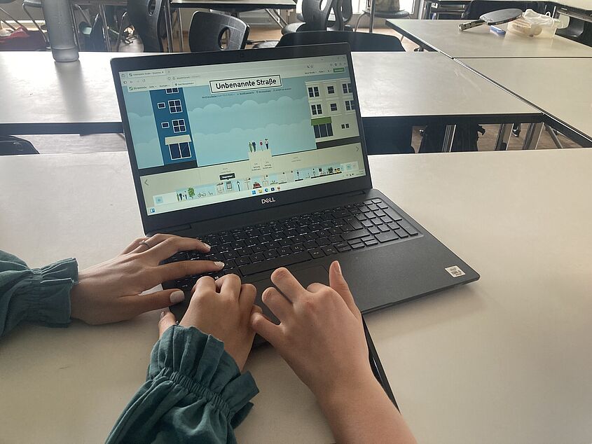 Hände sind in der Nahaufnahme an einem Laptop zu sehen