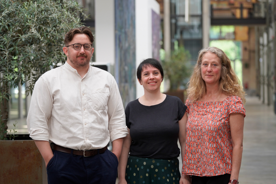 Teamfoto Wissenschaftliche Weiterbildung Drei Personen lächeln in die Kamera
