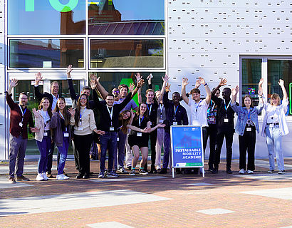 Jubelnde Teilnehmende der Sustainable Mobility Summer Academy 2023 vor Haus 16 auf dem Campus der TH Wildau 