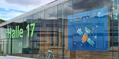 Banner der THCONNECT an der Scheibe in Halle 17 auf dem Campus der TH Wildau