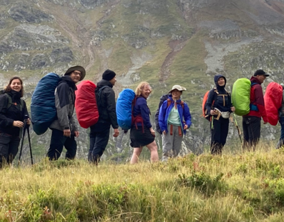 Menschen in Wanderkleidung auf einem Hang 