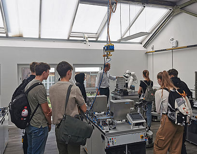 Schülerinnen und Schüler im Automatisierungstechnik-Labor beim Betrachten der Technik