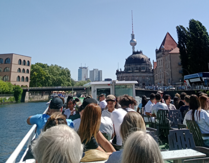 Menschen sitzen auf einem Ausflugsboot auf der Spree in Berlin