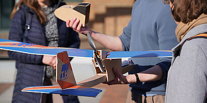 Studierende mit Modellflugzeug auf dem Campus