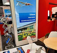 Vom 5. bis 9. Juni 2024 präsentiert sich auch die TH Wildau mit einem Stand auf der Internationalen Messe für Luft- und Raumfahrt (ILA) Bild: Christine Richert / TH Wildau Messestand der TH Wildau auf der ILA mit Ausstellunsstücken und Informationsmaterial
