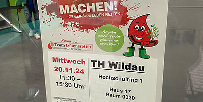 Plakat mit einem Aufruf zur Blutspende an einer Glastür