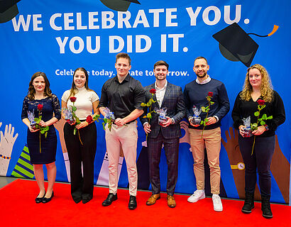 Absolvent*innen lassen bei der Verabschiedung 2025 ein Gruppenfoto aufnehmen