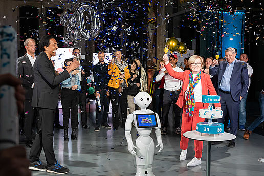 Cherno Jobatey, Roboter Bernd, Prof. Ulrike Tippe und Gäste bei der Jubiläumsfeier zum 30. Geburtstag