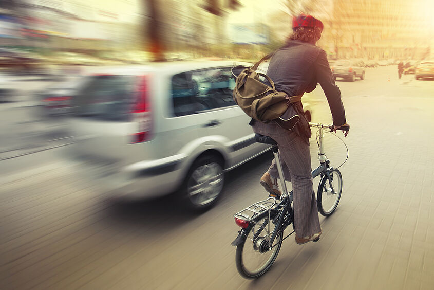 Radverkehr Radfahrer neben Auto auf der Straße