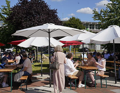 Alumni unterhalten sich beim Homecoming Day auf der Wiese 