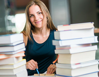 Studentin mit Büchern in der Bibliothek