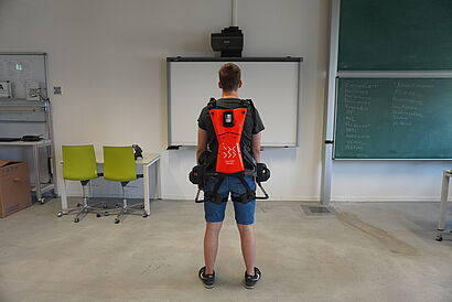 Person mit Exoskelett, Ansicht von hinten