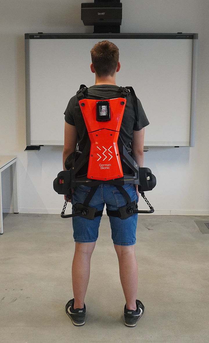 Person mit Exoskelett, Ansicht von hinten
