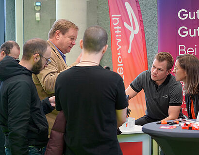 Ausstellende und Besucher*innen im Gespräch an einem Stand bei der THCONNECT 2025