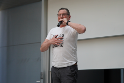 Person präsentiert T-Shirt mit QR-Code