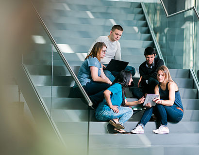 Studierende auf Treppe sitzend in Halle 17