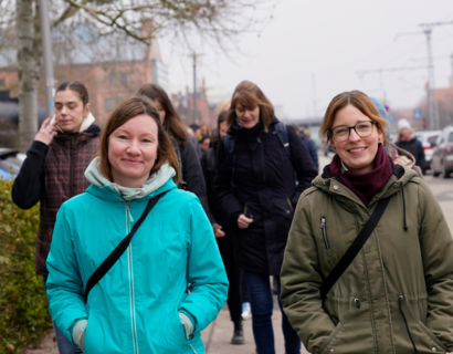 Zwei Frauen laufen lächelnd auf Kamera zu