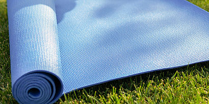Blaue Yoga-Matte auf Wiese