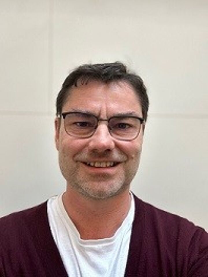 Porträtbild von Dr. Markus Glöckner, der in die Kamera lächelt.