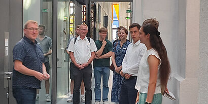 Gruppe von Menschen steht in einer Halle der TH Wildau in der Runde und ist im Gespräch