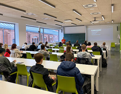 Schülerinnen und Schüler blicken beim Fachtag Informatik 2023 der TH Wildau in einem Seminarraum nach vorn zum Dozierenden