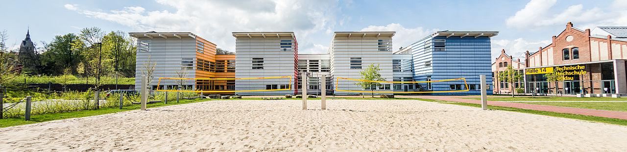 Blick auf das Beachvolleyballfeld und Haus 15