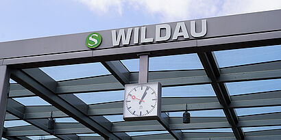Große Uhr am Bahnhof Wildau mit dem Schriftzug "Wildau" am Glasgebäude