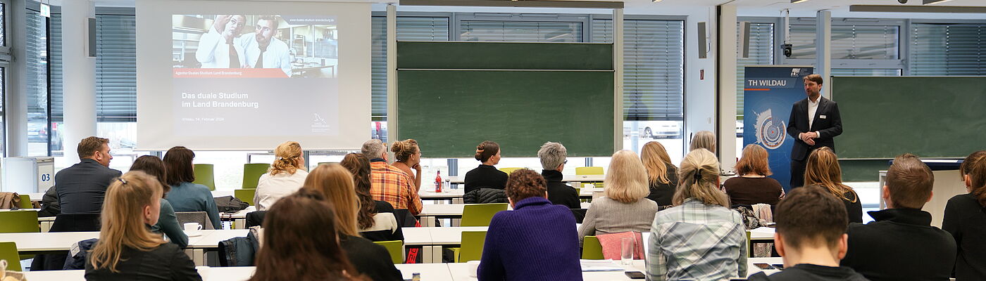 Teilnehmende einer Veranstaltung zum Vernetzten zum Thema Dualen Studium in einem Hörsaal der TH Wildau bei einem Vortrag von Prof. Stollhoff