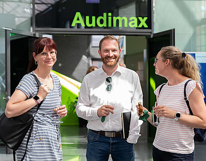 Drei Personen vor dem Audimax 