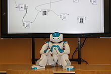 MINT-Tag Humanoider Roboter auf Tisch vor einem Bildschirm