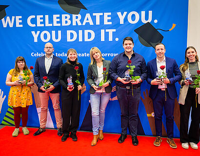 Absolvent*innen lassen bei der Verabschiedung 2025 ein Gruppenfoto aufnehmen